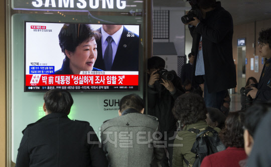 박근혜 전 대통령이 피의자로 검찰에 출석한 21일 서울역에서 시민들이 발길을 멈춘 채 박 전 대통령의 검찰 출석 모습을 TV 화면을 통해 지켜보고 있다. 유동일기자 eddieyou@